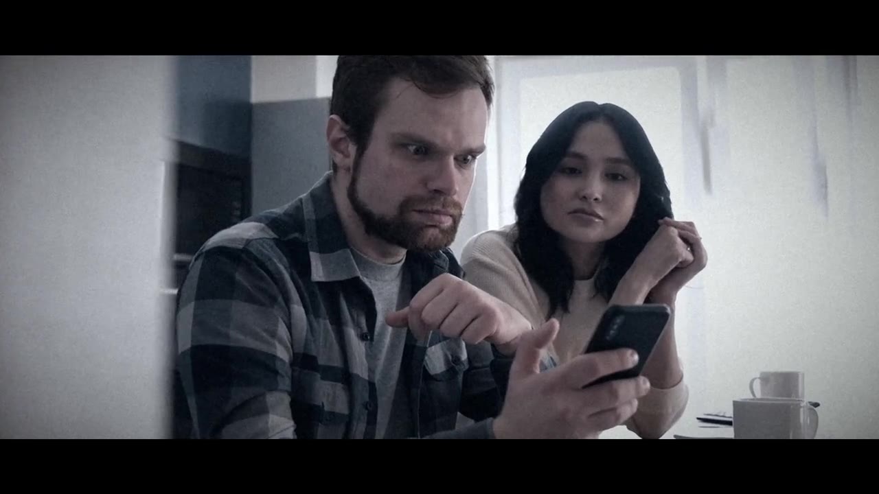 A couple looking at a phone at night